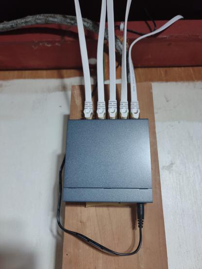 Grey ethernet switch feeding 4 new white cables.