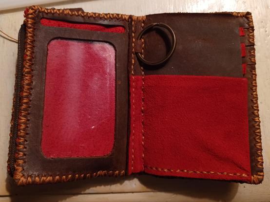 A red and brown wallet interior with two pockets and a key ring.