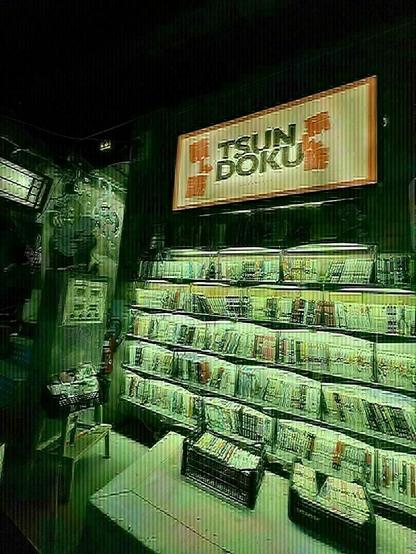 Photo de la
Partie cachée de la librairie  Tsundoku avec les mangas d’occasion dans la pénombre