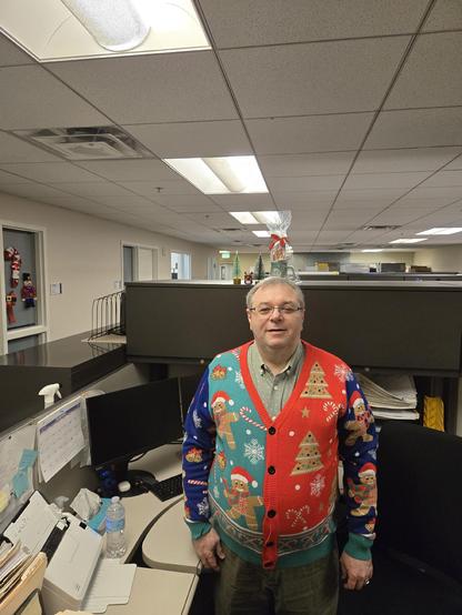 Middle aged Man wearing a Christmas themed sweater.