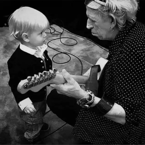 Keith playing guitar to a wee laddie.