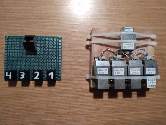 On the right a 4x RJ45 (center pair) to 1x RJ45 adapter, built from a 4-port patch module and a keystone, fastened to a piece of wood with zipties.

On the left a 1x RJ45 to 4x RJ11 (center pair) adapter on a hole-matrix PCB.