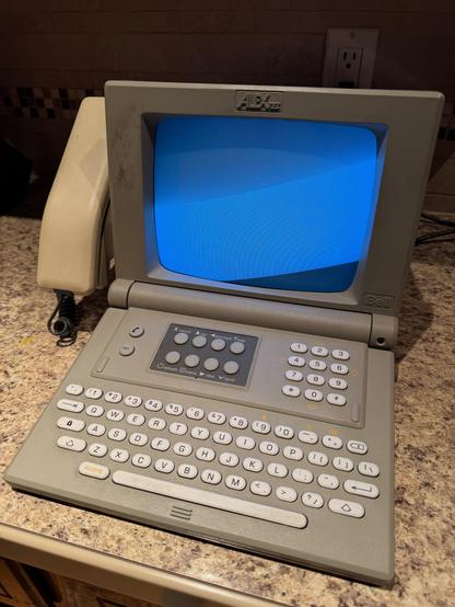 A powered on Alextel terminal. The screen is lit up, but blank.