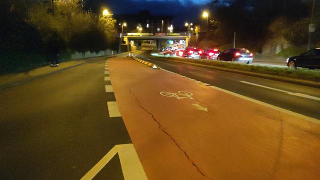 Breite rote Fahrradfahrspur bei Nacht
