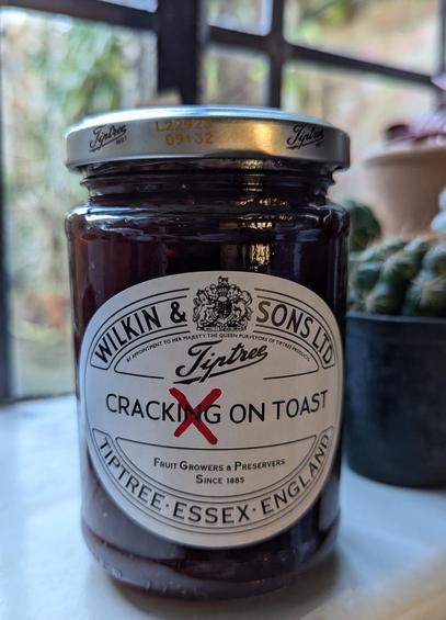 Photograph of a jar of Tiptree jam. There is a customised label which reads "Cracking on Toast". The "ing" has been crossed out with red marker pen so it reads "Crack on Toast". 

Take that big preserve, you can't defeat me.