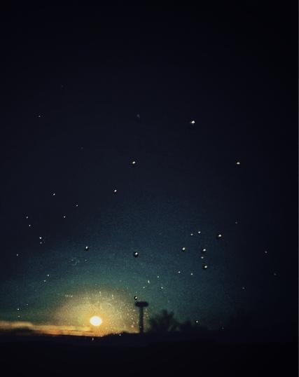 Lights against a dark sky during sunrise.