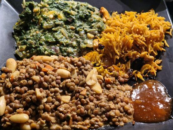 Dal, Reis, Aloo Palak, Chutney. Auf schwarzem eckigen Teller