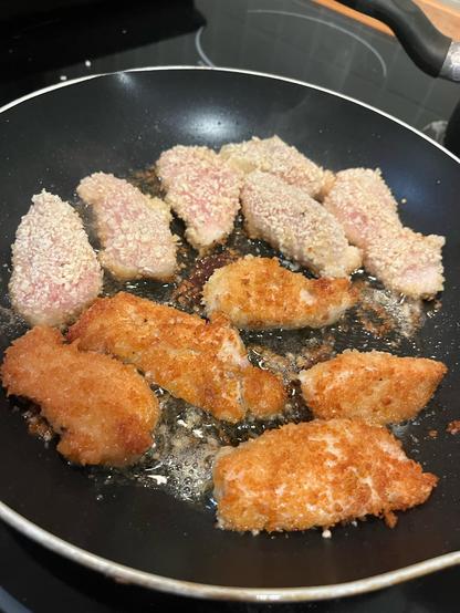 un sartén con pollo empanizado siendo frito