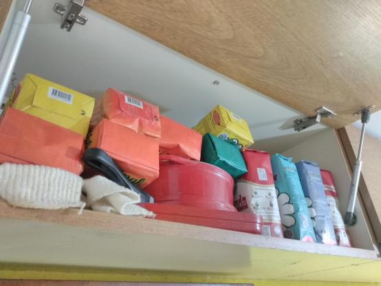 Fotografía de una alacena de cocina, donde se ven dentro bastantes paquetes de yerba en varias presentaciones (aunque quizá de la misma marca)