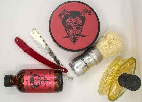 A red Weck Sextoblade between a tub of BaM Fougère Gothique soap and a matching splash, a big Zenith B8 boar brush, and a bottle of Brut original frag