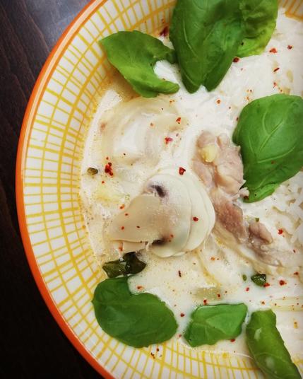 Soupe crémeuse avec morceaux de poulet, champi et herbes
