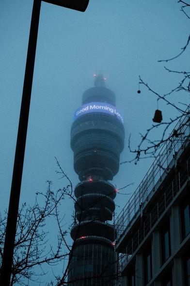Very gloomy look up at the BT tower with it's top hidden by fog.