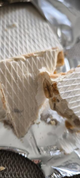 La foto muestra un turrón de Alicante en trozos con su oblea y sus almendras