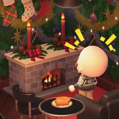Animal Crossing: New Horizon screenshot. Image shows a bald, bearded light skinned human villager in a black snowflake sweater in a room with herringbone wooden floor and holiday wallpaper. The bald human is laughing in front of a white fireplace with two red festive candles on top. There are a black set of furniture including a cool chair, cool side table, and cool couch nearby. A small plate with a Brewster cookie is on the table.