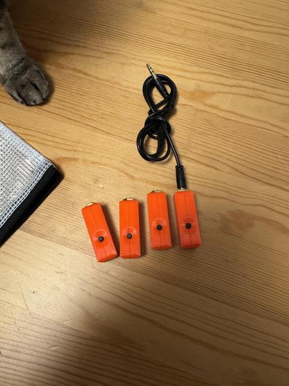 Four fully assembled mics in orange PETG housing.