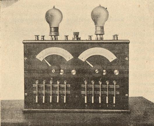 A picture from 1919 of (one of) the first multivibrators built, a wooden box with two vacuum tubes on top and on the front panel two sets of switches and two dials for adjusting the period.