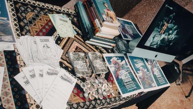 Fotografía. Mesa con parafernalia de "Secretaría de Asuntos Paranormales", juego de rol desarrollado por "Leyendas del Noreste".