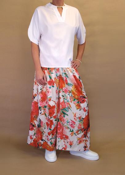 I’m posing in my floral pattern skirt pants and a white v-neck short sleeved blouse and chunky white sneakers with kawaii ankle socks. I’m also wearing silver pearl necklace and armband. Seen from the front as I’m turning my left foot outwards and resting my left hand on my hip.