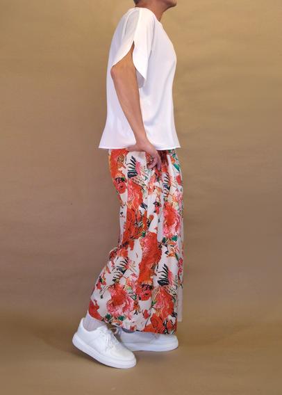 I’m posing in my floral pattern skirt pants and a white v-neck short sleeved blouse and chunky white sneakers with kawaii ankle socks. I’m also wearing silver pearl necklace and armband. Seen from my right as I’m lifting my right heel and resting my right hand on my hip.