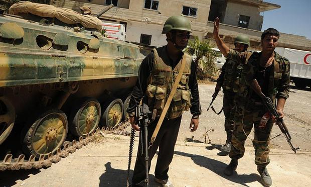 Fuerzas del Gobierno sirio de Assad, combatiendo contra el Ejército Libre Sirio en la aldea de Houla, el 26 de mayo de 2012. (Kaveh Kazemi / Getty)