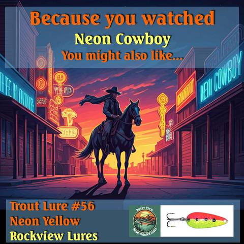 In a deliberate nonsequiter juxtaposition,  a cartoon image of a western movie town main street with a silhouette of a cowboy on a horse against a neon yellow/orange/purpe sky. The text reads, because you watched Neon Cowboy you might also like... and then an insert of Trout Lure #56 Neon Yellow from Rockyview Lures.