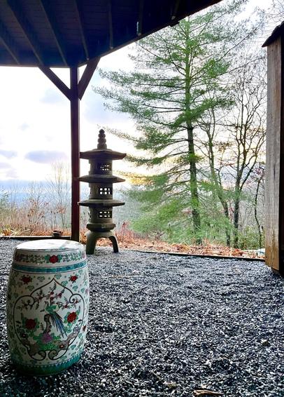 Stone lantern, garden seat, wooden hut white pine and mountain in surrounding landscape form zen gard n elements in the mountains of western norh carolina.