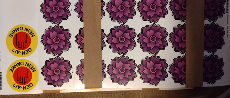 a photo of a bunch of sticker sheets with ~500 Amaranth logo stickers