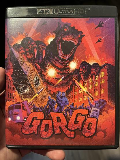 A DVD cover for the film "Gorgo." The artwork features a monstrous creature wreaking havoc in a cityscape, with explosions, military jets, and terrified people. The title "Gorgo" is prominently displayed in bold, stylized