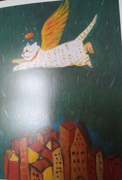 Photo of greeting card
White cat with wings and a halo, flying over buildings