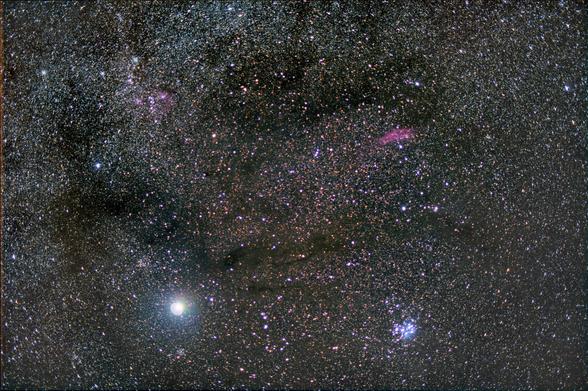 Dark dust lanes across the Milky Way. Jupiter is the brightest object in the lower left corner. Most of the constellation Auriga is in the upper left quadrant. The Pleiades are in the lower right quadrant, and the pink/red California Nebula is in the upper right quadrant.