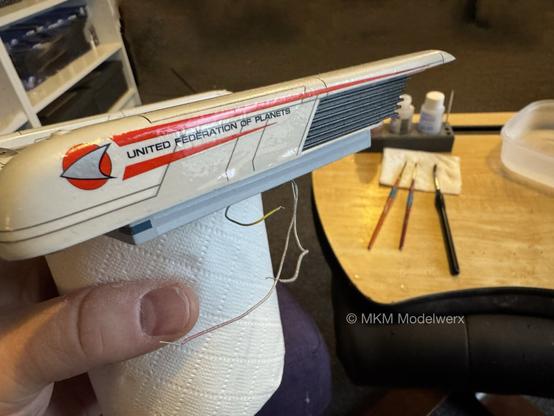 Port nacelle showing the insignia decal with the words “United Federation of Planets” between the two red stripes.