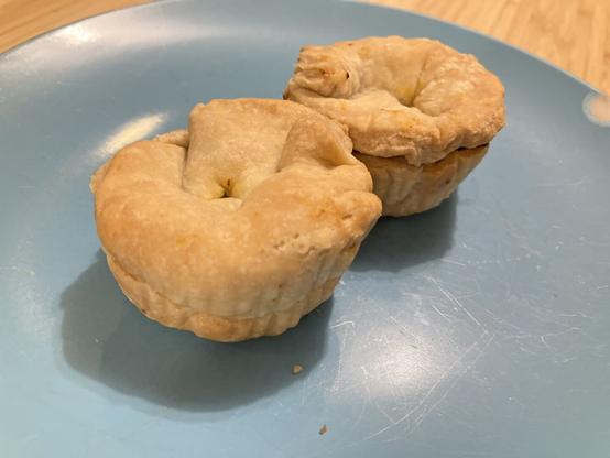 Two small muffin size meat pies on a plate.