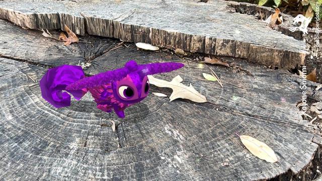 A purple and pink dot with the horns chaos trait Rampage Drive standing on a tree stump.