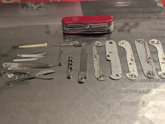 Swiss army knife back from repair with all it's replaced parts knolled out on the table