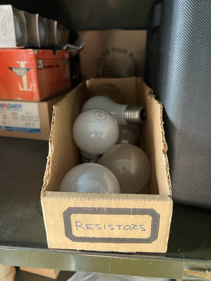 A cardboard box that contains incandescent light bulbs. The label on the front of the box says resistors.