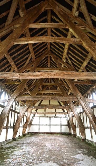 Empty old barn with curved beams from the roof to the floor