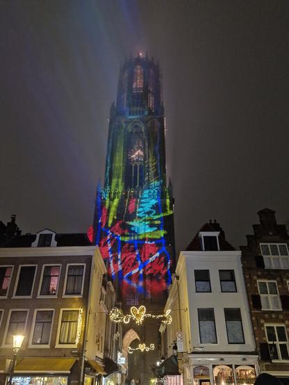 Photo of a cathedral wjth bright red green and blue scribbles projected on to it