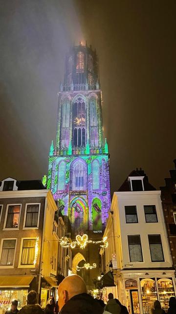 Photo of a cathedral with fatasy-mood lila and turquoise projected on to it, with drawings of candy on various parts of the buiding