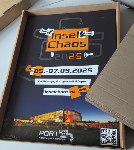 Ein Paket voller Poster für das InselChaos  liegt auf dem Tisch.