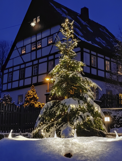 Closer view shot from a little artificial fountain in front of it. A big wreath is put on it during Advent with four big electrical candles half buried under the snow illuminating the foreground.
