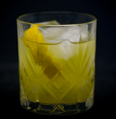The first cocktail, yellow in color with a lemon twist.