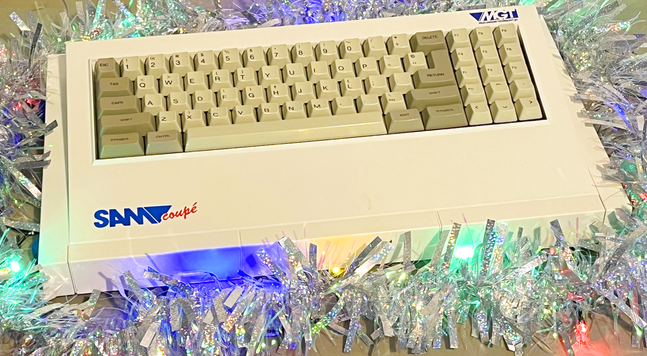 A SAM Coupe computer, surrounded by tinsel and lights