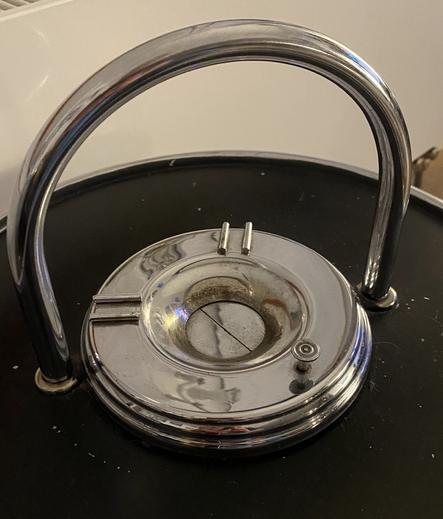 An einer Seite befindet sich ein Druckknopf, bei dessen Betätigung sich innen zwei Klappen öffnen.