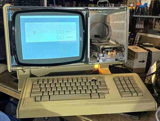 Lisa 2/5 with front panel removed, powered up showing the boot device selection screen.