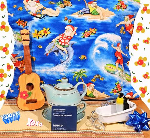 A tropical tea tableau depicting Santa Claus surfing the South Seas on a dolphin in blazing sunshine while a penguin inexplicably recovers in a clawfoot bathtub from what was obviously a wild party. There's also an ukulele in the corner. The tea is called Santa's Secret, from David's Teas.