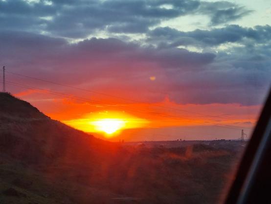 Il sole al tramonto incendia l'orizzonte di rosso