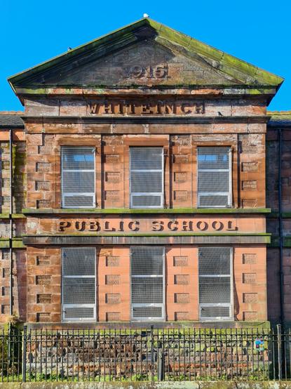 A red sandstone school building with the words Whiteinch Public School carved onto it.