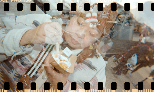 A woman eats little pancakes and there’s a double exposure.