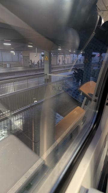 Blick aus dem Fenster eines Regionalzug auf den fast leeren Bahnsteig vor der Abfahrt des Zuges