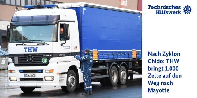 Ein Mensch in Einsatzkleidung des Technischen Hilfswerks steht neben einem großen Lastwagen.